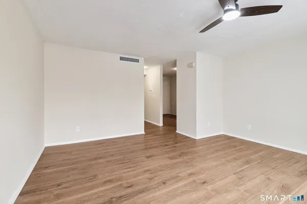 a view of an empty room with wooden floor
