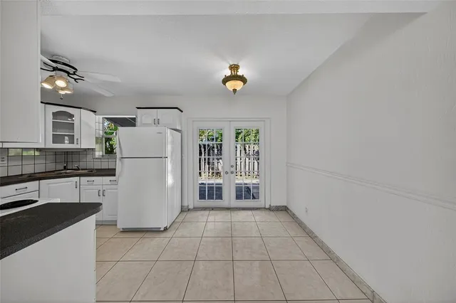 a kitchen with a refrigerator a stove top oven and cabinets