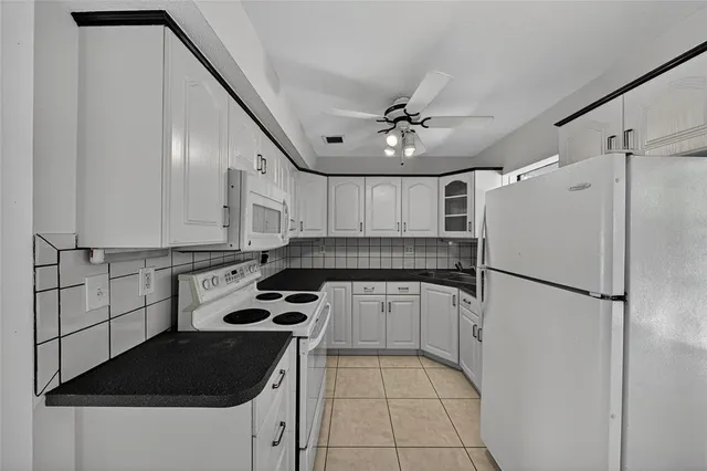 a kitchen with a refrigerator a stove top oven and a sink