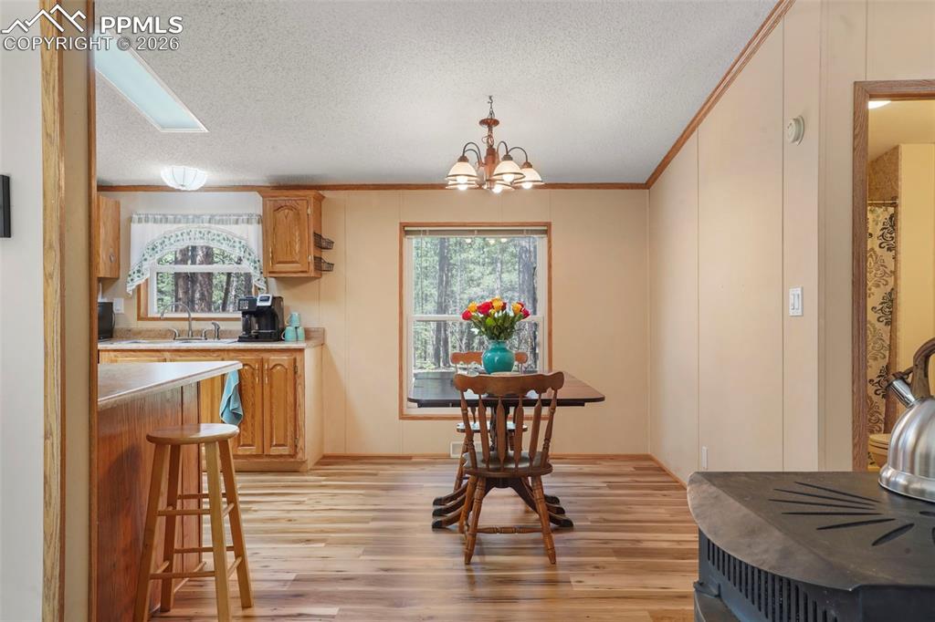 2450 Pathfinder Road Florissant, CO 80816 - Photo 7 of 29 a view of a dining room with furniture wooden floor and a chandelier