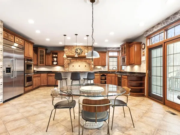 a kitchen with stainless steel appliances kitchen island granite countertop a dining table chairs and granite counter tops