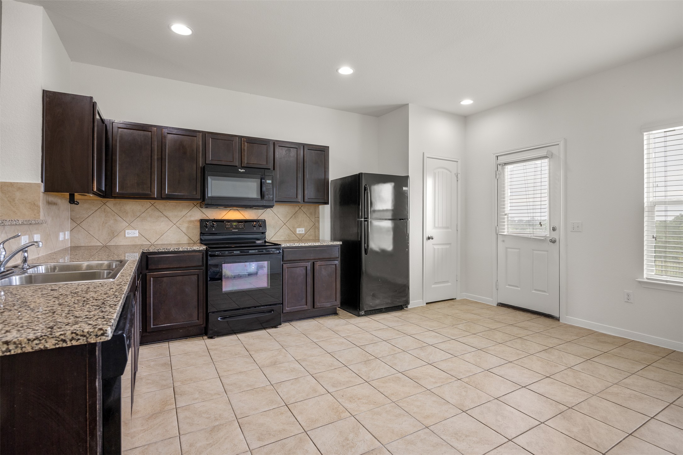 703 Liard River Road Hutto, TX 78634 - Photo 6 of 16 Functional kitchen with ample cabinet space, granite countertops, and modern appliances.