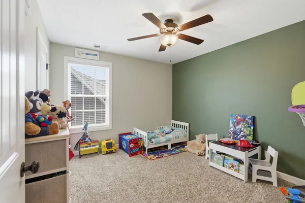 a bedroom with a bed and a chandelier fan