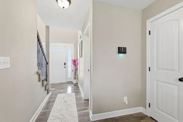 a view of a hallway with wooden floor and entryway