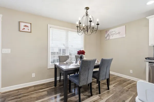 a view of a dining room with furniture wooden floor and a chandelier