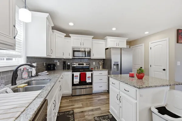 a kitchen with stainless steel appliances granite countertop a sink stove and refrigerator