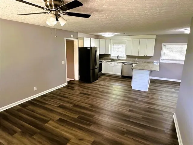 a kitchen with a refrigerator sink and cabinets