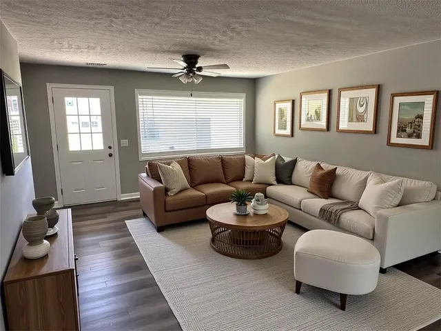 a kitchen with stainless steel appliances granite countertop a refrigerator coffee maker on granite counter tops and white cabinets with wooden floor