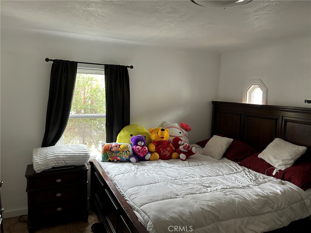 10205 Bryson Avenue South Gate, CA 90280 - Photo 14 of 35 a bedroom with a bed and window