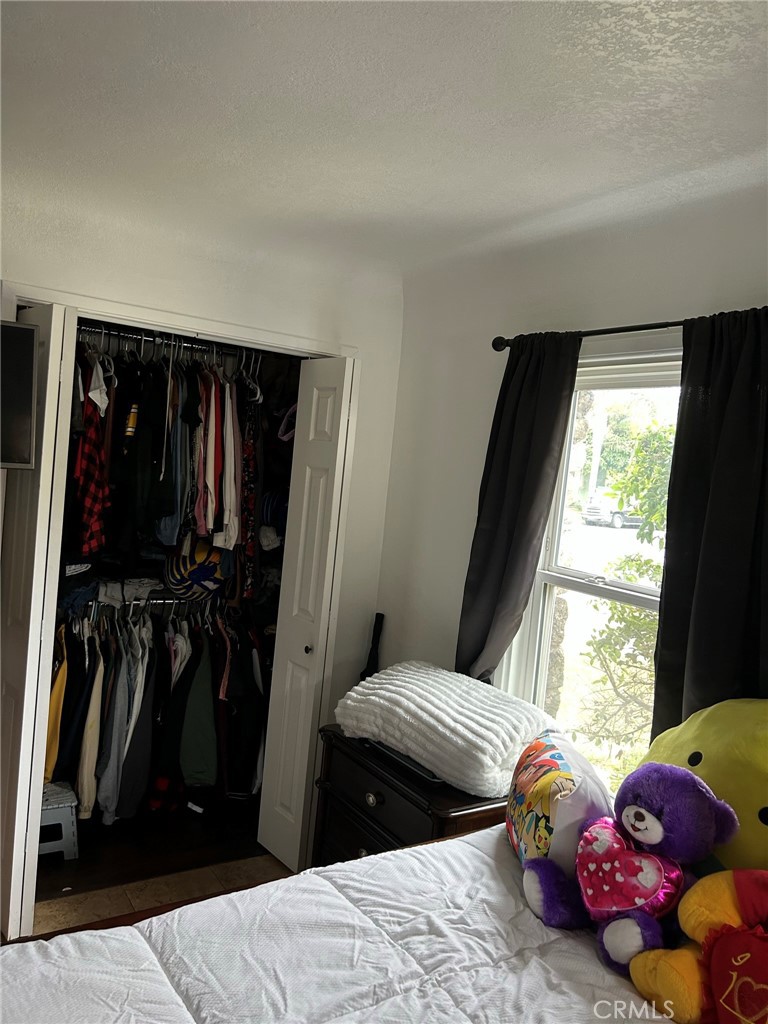 10205 Bryson Avenue South Gate, CA 90280 - Photo 16 of 35 a bedroom with a bed a window and walk in closet