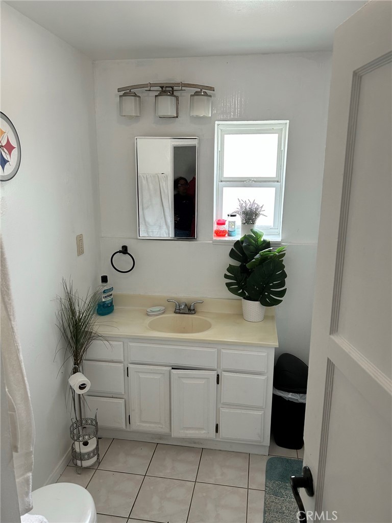 10205 Bryson Avenue South Gate, CA 90280 - Photo 18 of 35 a bathroom with a sink a toilet and a mirror