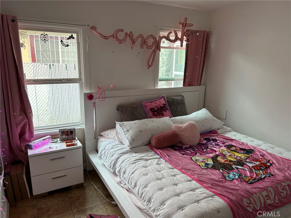 10205 Bryson Avenue South Gate, CA 90280 - Photo 20 of 35 a bedroom with a bed wooden floor and window