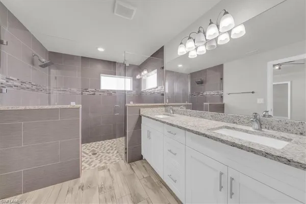 an empty room with wooden floor and ceiling fan