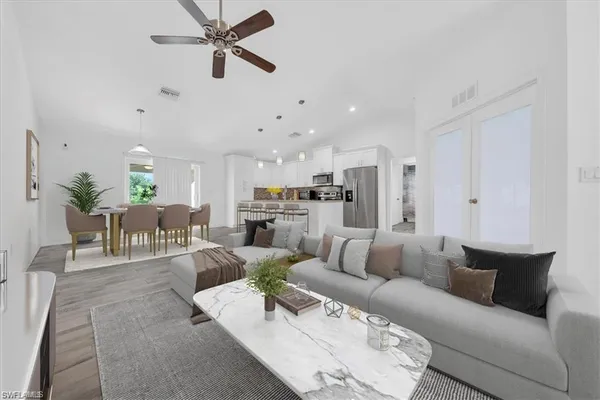 a living room with furniture kitchen view and a chandelier