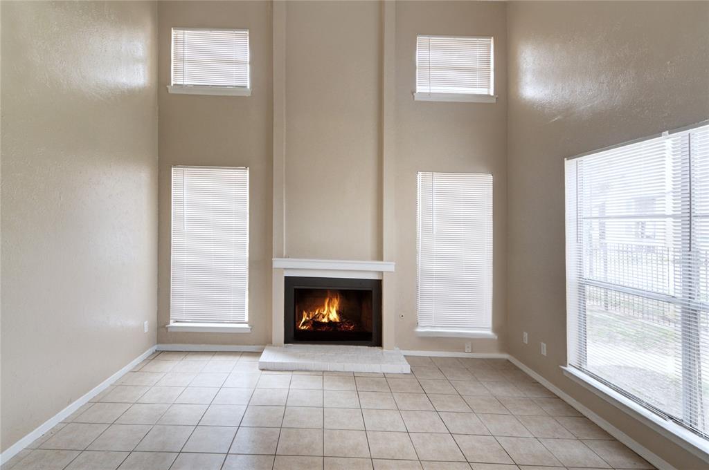 a view of an empty room with a window and a fireplace