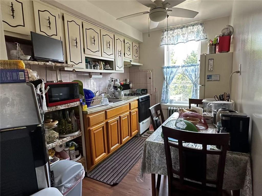 627 50th Street Brooklyn, NY 11220 - Photo 4 of 9 a kitchen with stainless steel appliances a stove a sink dishwasher a dining table and chairs with cabinets