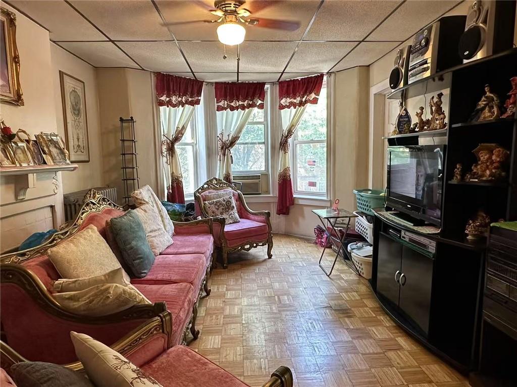 627 50th Street Brooklyn, NY 11220 - Photo 5 of 9 a living room with furniture a flat screen tv and a floor to ceiling window