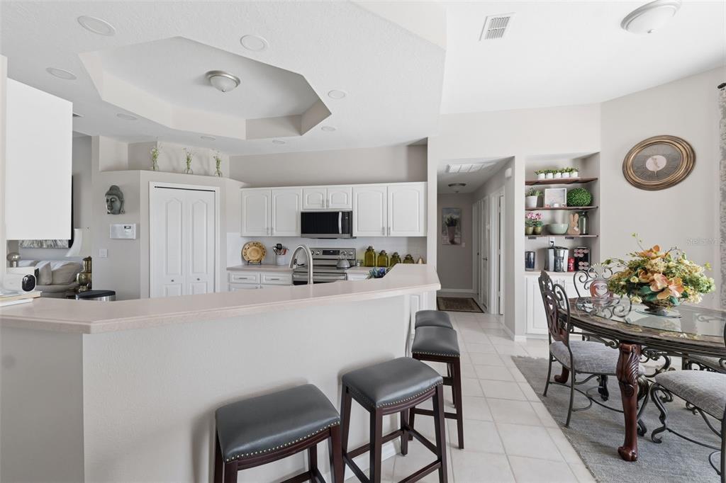 14126 Andrew Scott Road Spring Hill, FL 34609 - Photo 12 of 29 a kitchen with stainless steel appliances kitchen island a table and chairs in it