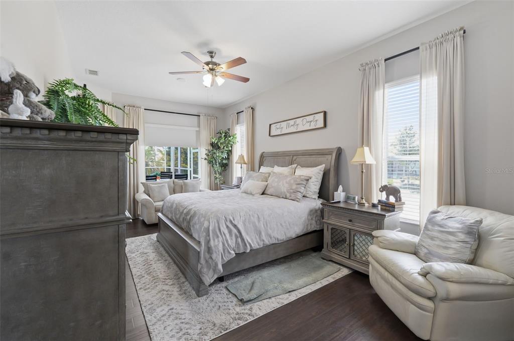 14126 Andrew Scott Road Spring Hill, FL 34609 - Photo 18 of 29 a spacious bedroom with a bed and a chandelier