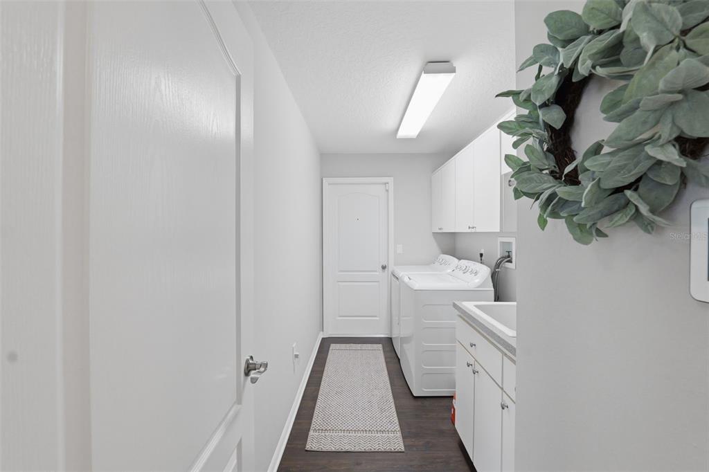 14126 Andrew Scott Road Spring Hill, FL 34609 - Photo 20 of 29 a hallway with white cabinets and sink