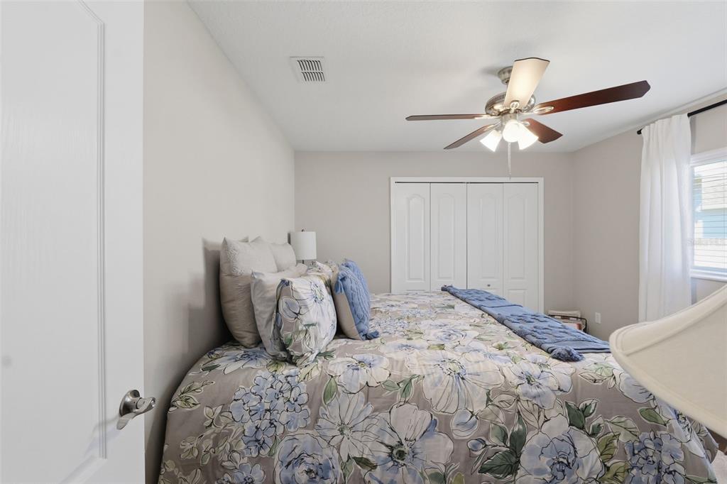 14126 Andrew Scott Road Spring Hill, FL 34609 - Photo 23 of 29 a bedroom with a large bed and a ceiling fan
