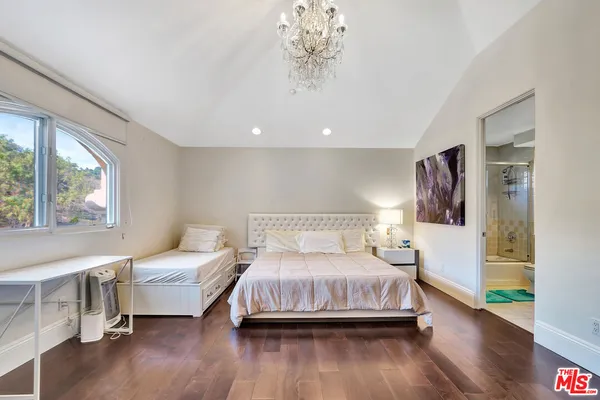 a bathroom with a bathtub shower sink vanity mirror and toilet