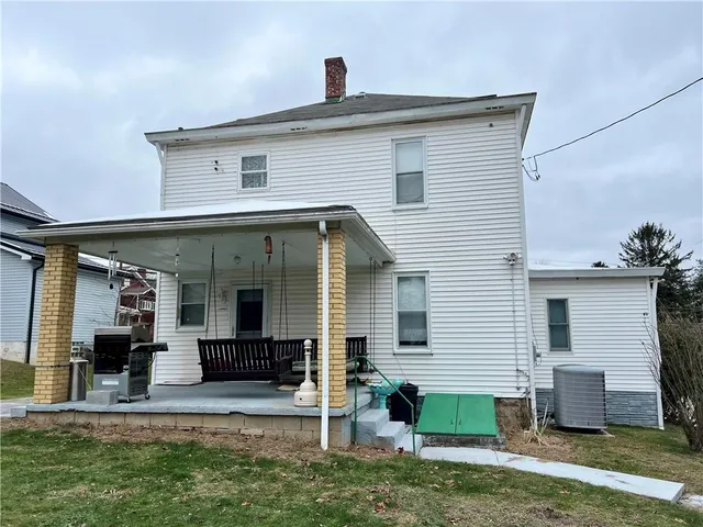 a view of a house with a yard and a table and chairs