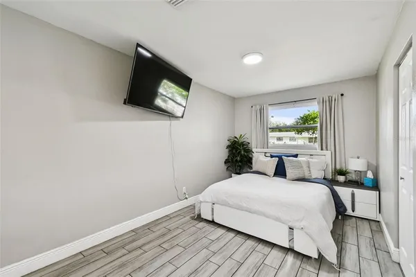 a bedroom with a bed and a flat screen tv