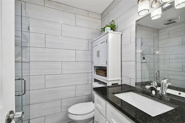 a bathroom with a sink a toilet and shower