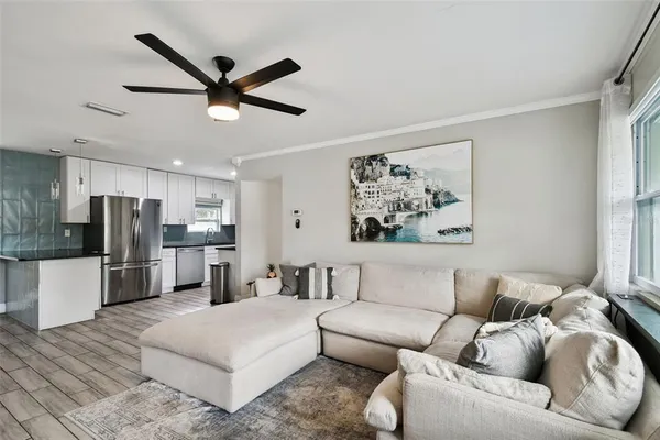 a living room with stainless steel appliances furniture and a window