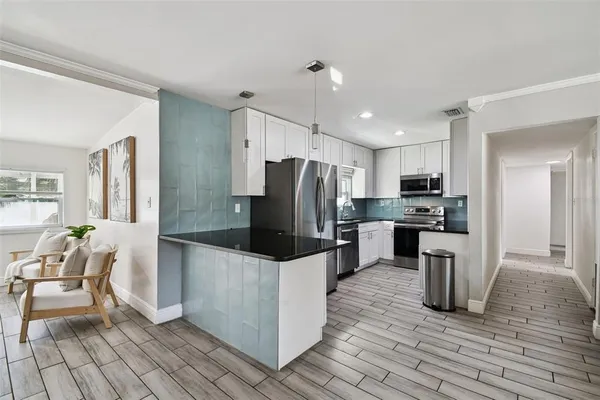 a kitchen with a refrigerator and a stove top oven