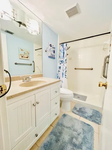 a spacious bathroom with a granite countertop sink a toilet and a shower