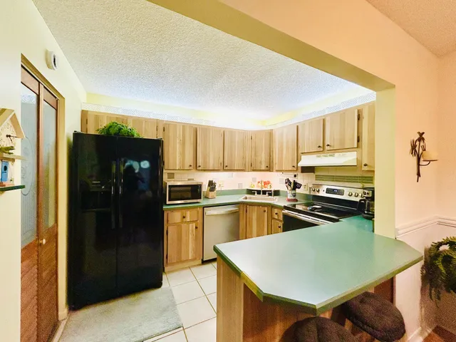 a kitchen with stainless steel appliances granite countertop a refrigerator and a stove top oven