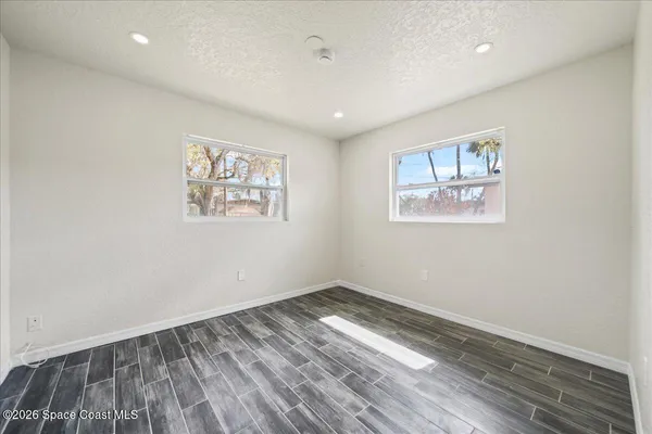 a view of empty room with wooden floor