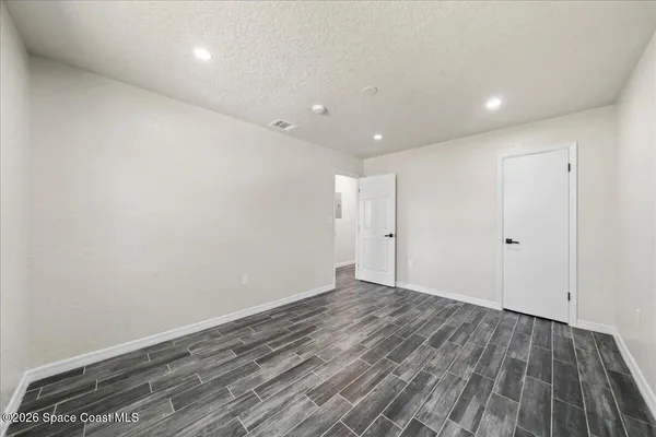 a view of an empty room with wooden floor