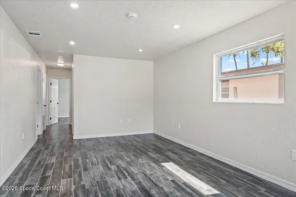 a view of a room with wooden floor and a window