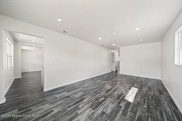 a view of empty room with wooden floor
