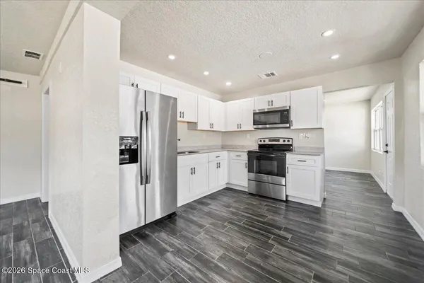 a kitchen with stainless steel appliances a refrigerator and a stove top oven