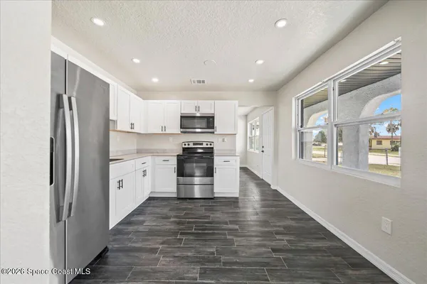 a kitchen with stainless steel appliances granite countertop a refrigerator and a stove top oven