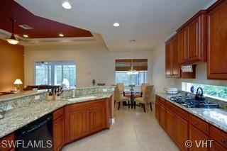 12643 Biscayne Court Naples, FL 34105 - Photo 3 of 8 a kitchen with granite countertop sink stove and cabinets