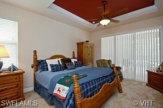 12643 Biscayne Court Naples, FL 34105 - Photo 6 of 8 a bedroom with a bed and a chandelier