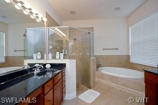 12643 Biscayne Court Naples, FL 34105 - Photo 7 of 8 a bathroom with a granite countertop sink a toilet a mirror and bathtub