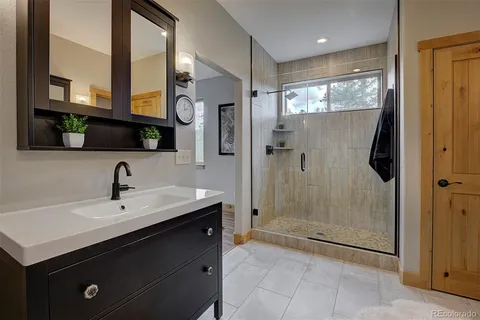 a bathroom with a shower sink and mirror