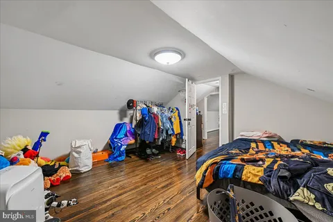 a bedroom with bed and a wooden floor