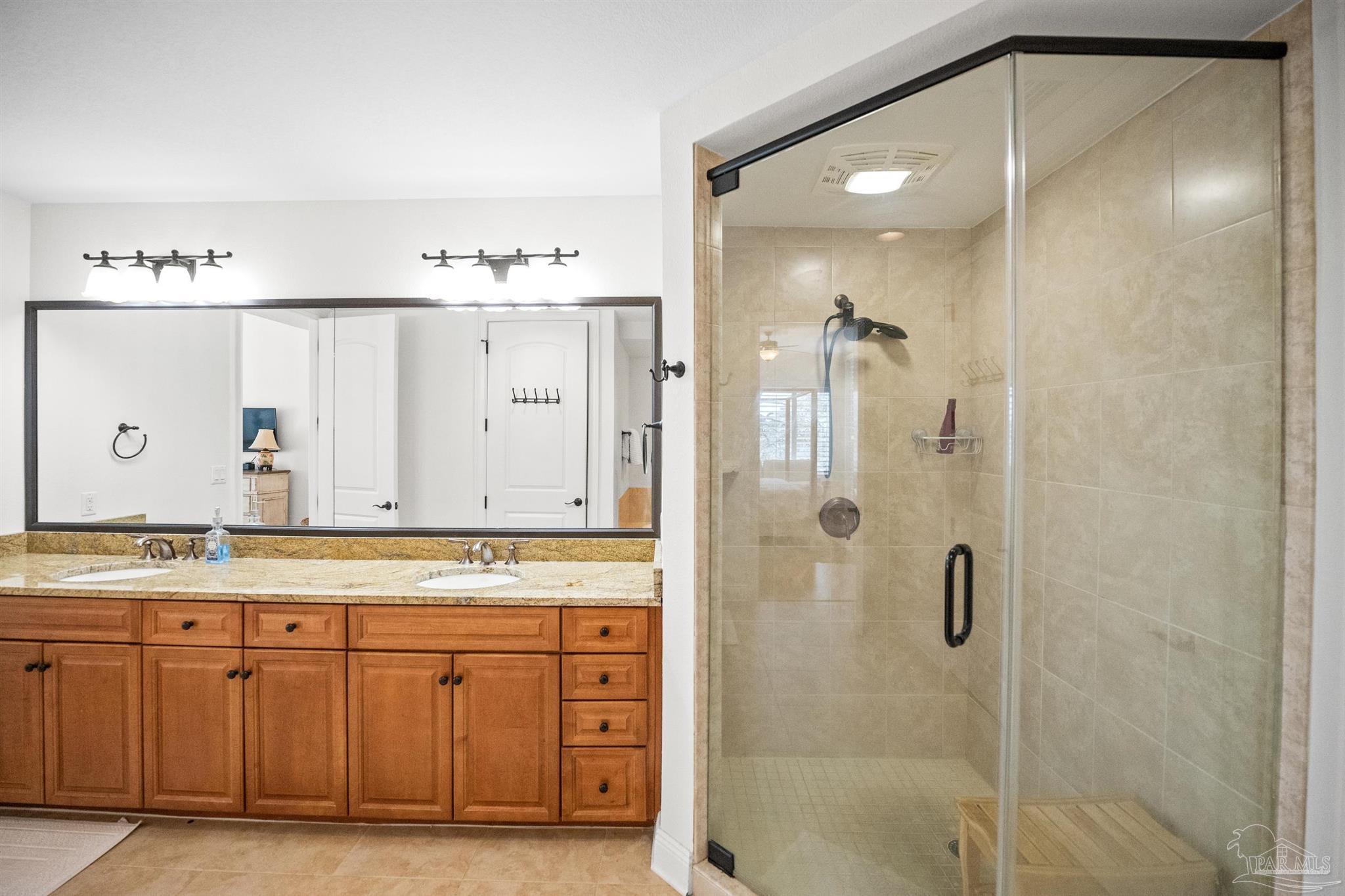 14500 River Road, Unit 101 Pensacola, FL 32507 - Photo 35 of 61 a bathroom with a granite countertop sink a shower and a mirror