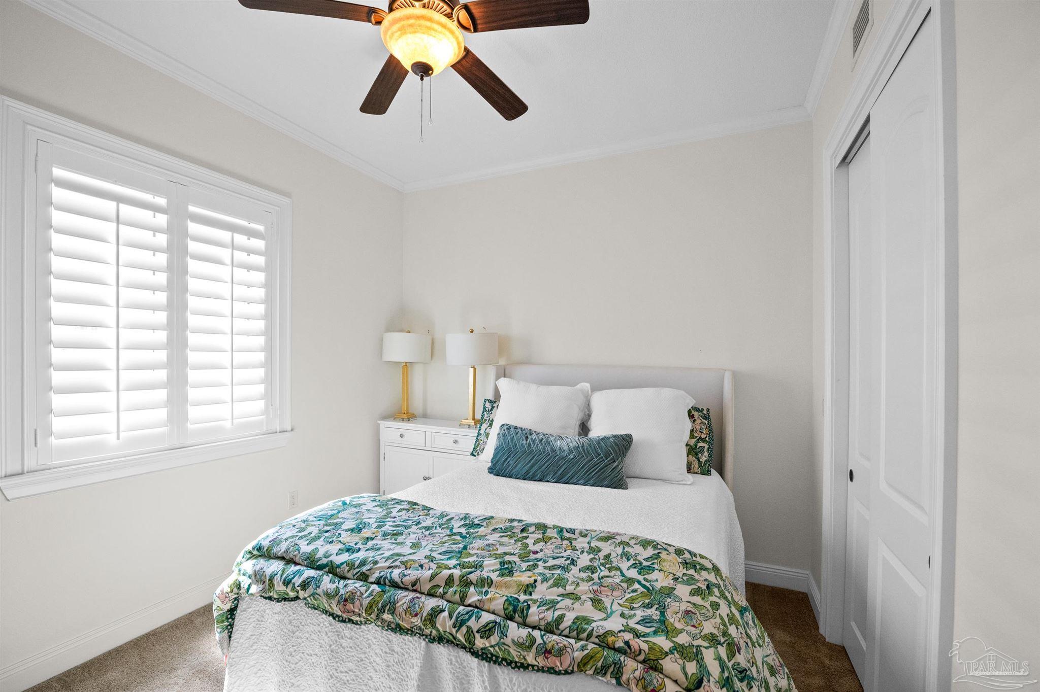 14500 River Road, Unit 101 Pensacola, FL 32507 - Photo 40 of 61 a bedroom with a bed and dresser with mirror