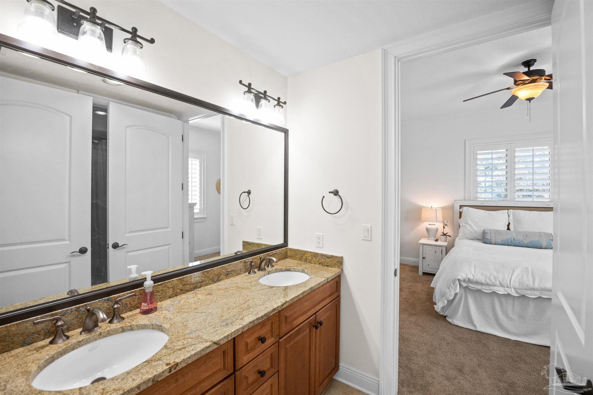 14500 River Road, Unit 101 Pensacola, FL 32507 - Photo 44 of 61 a en suite bathroom with a double vanity sink and a mirror