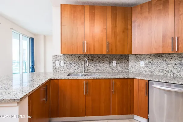 a bathroom with a granite countertop sink and a bathtub