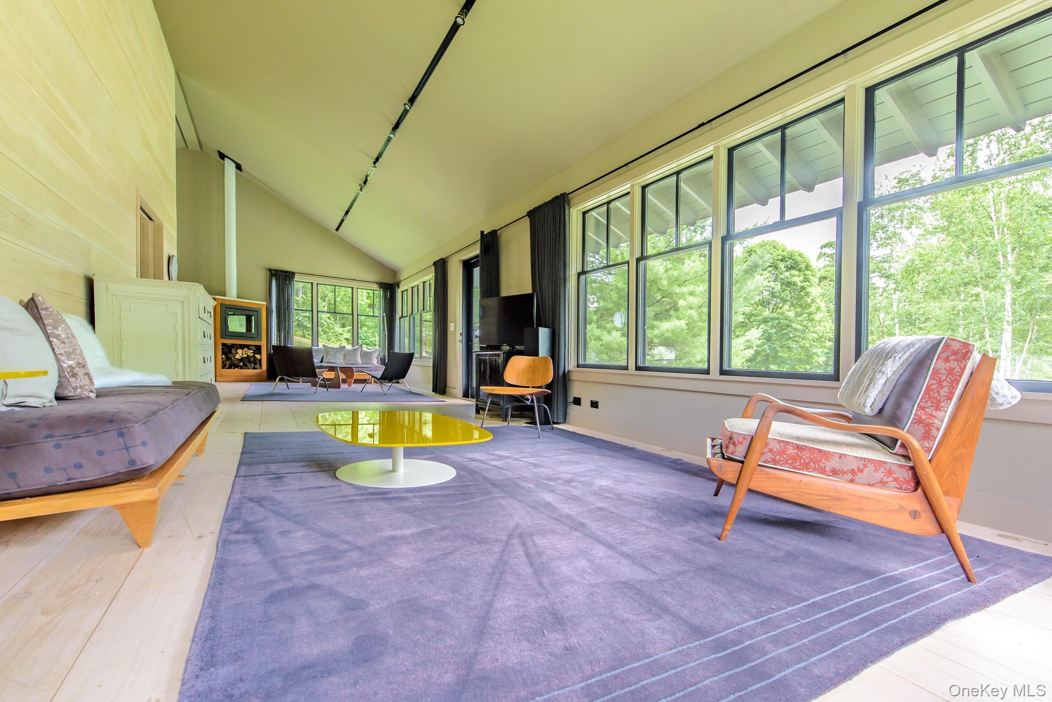 890 Bald Mountain Road Austerlitz, NY 12017 - Photo 18 of 28 Sunroom / solarium featuring high vaulted ceiling, a wood stove, and hardwood / wood-style floors