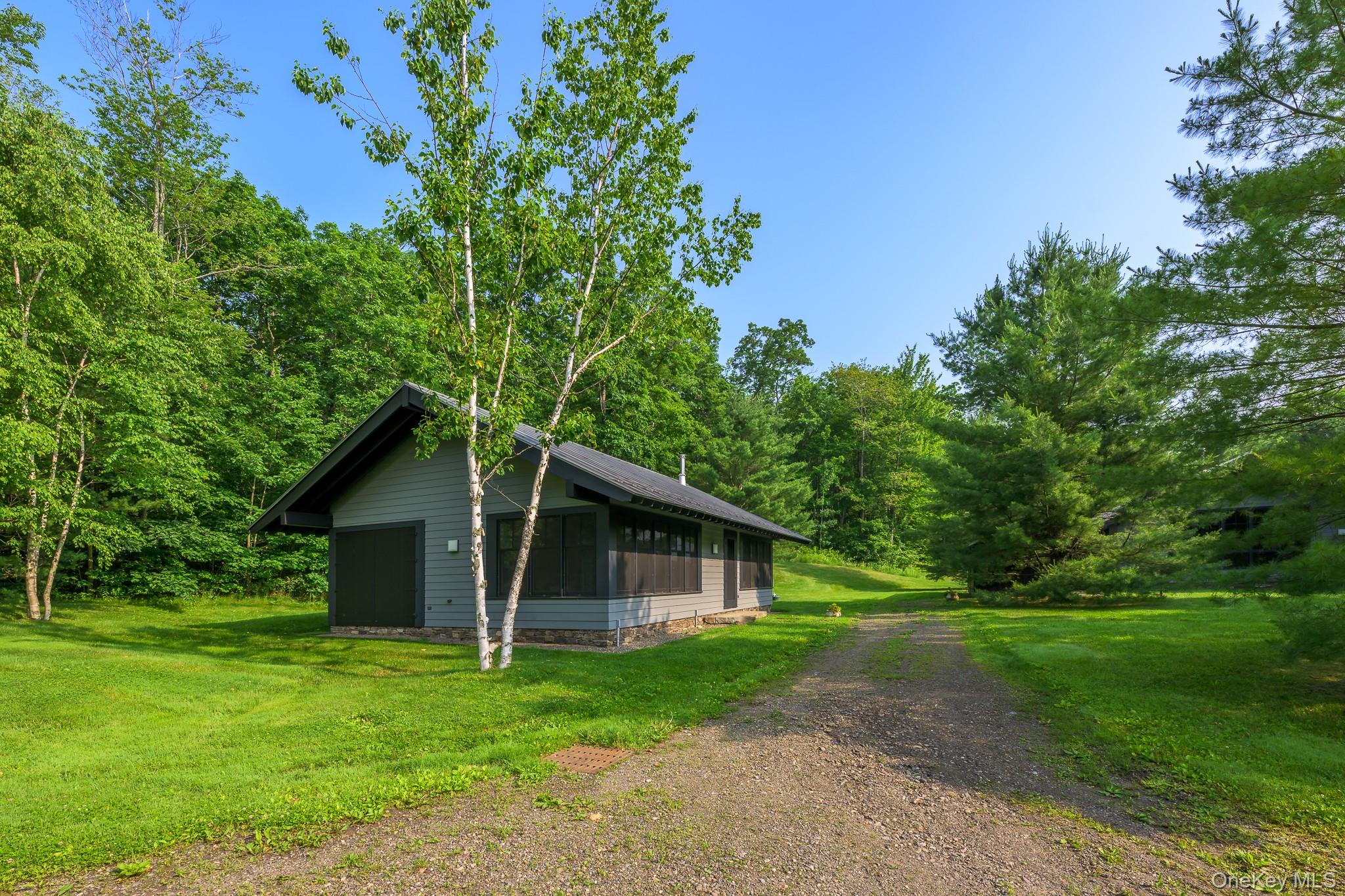 890 Bald Mountain Road Austerlitz, NY 12017 - Photo 19 of 28 View of side of home featuring a sunroom, a lawn, dirt driveway, and a wooded view